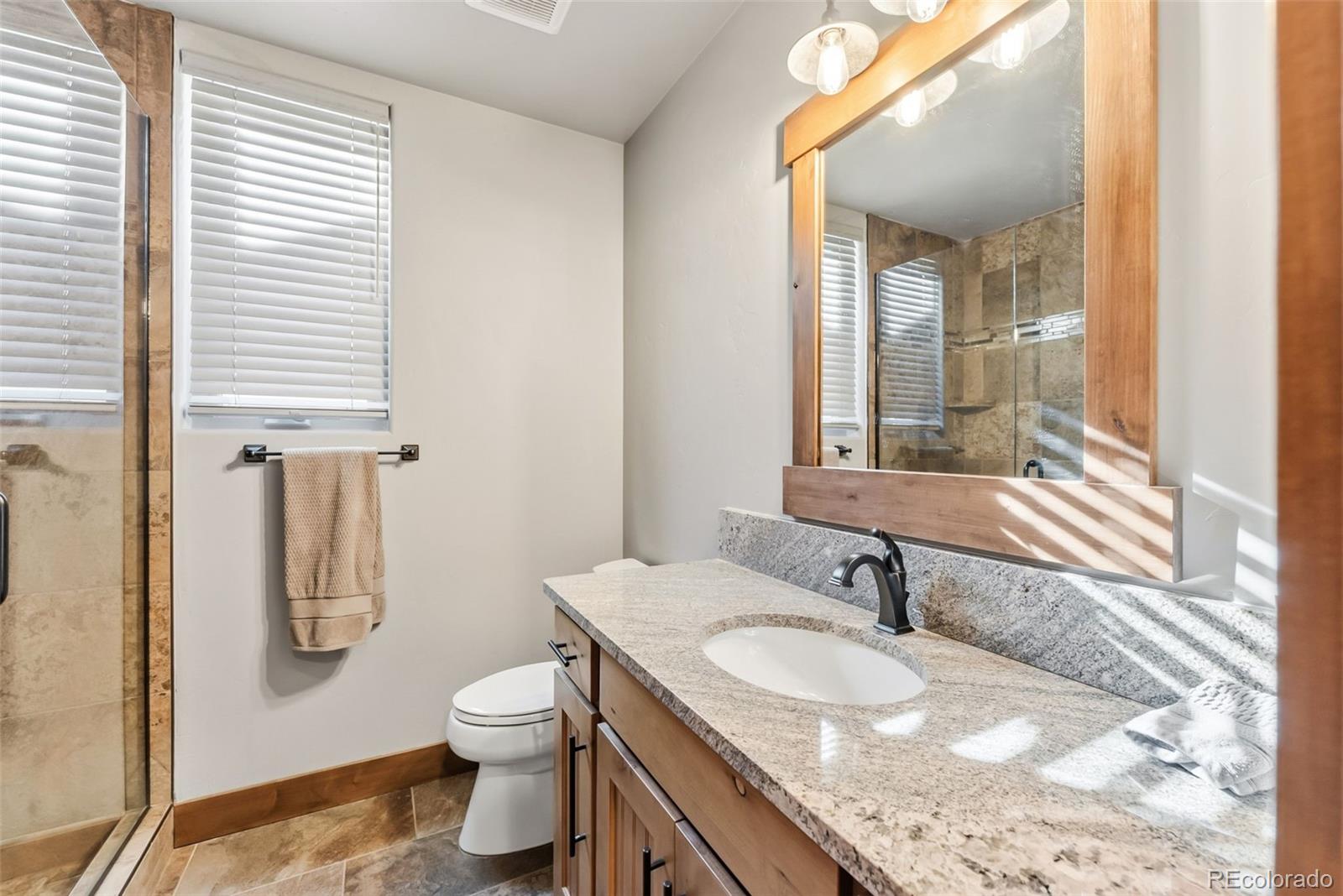 481 West Main Street, Unit B201 Frisco, CO 80443 - Photo 16 of 26 a bathroom with a granite countertop sink toilet and shower