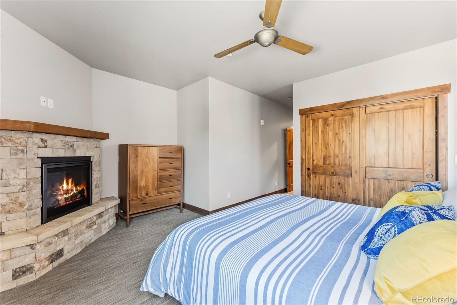 481 West Main Street, Unit B201 Frisco, CO 80443 - Photo 22 of 26 a bedroom with a bed a fireplace and a chandelier