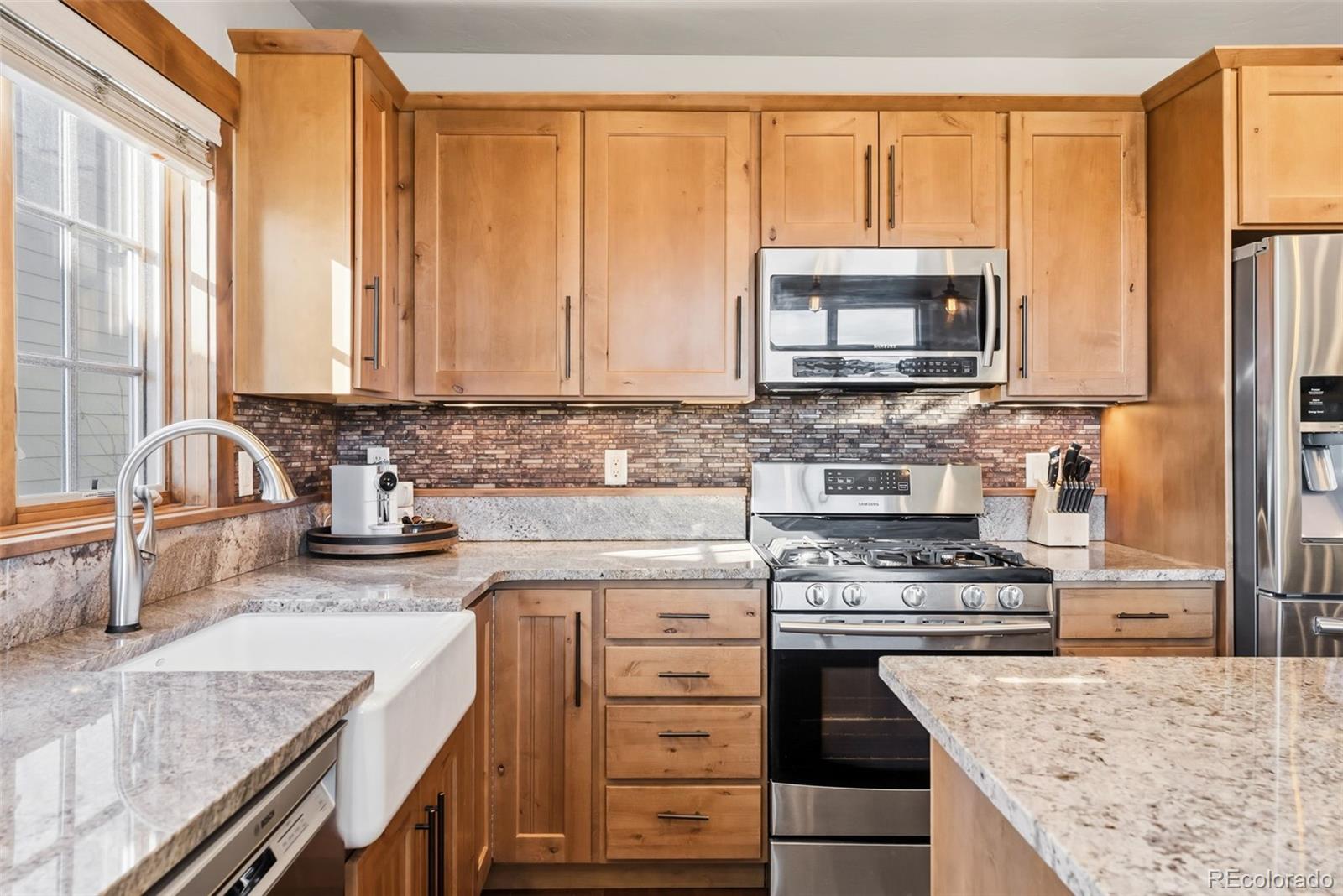 481 West Main Street, Unit B201 Frisco, CO 80443 - Photo 6 of 26 a kitchen with stainless steel appliances granite countertop a stove a sink and a microwave