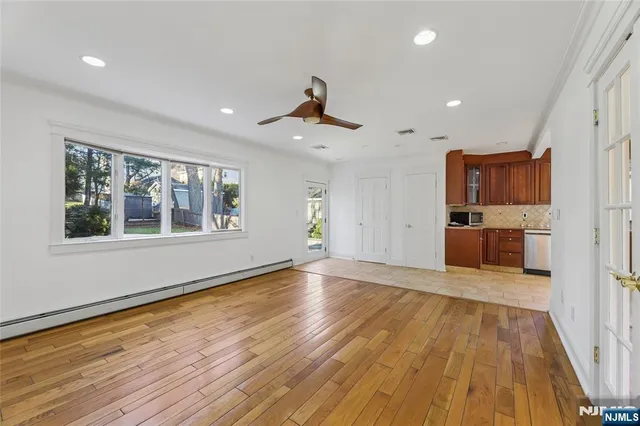 a view of empty room with wooden floor and windows