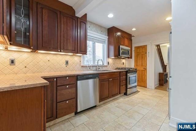 135 7th Street Cresskill, NJ 07626 - Photo 2 of 17 a kitchen with stainless steel appliances granite countertop wooden cabinets a sink and dishwasher