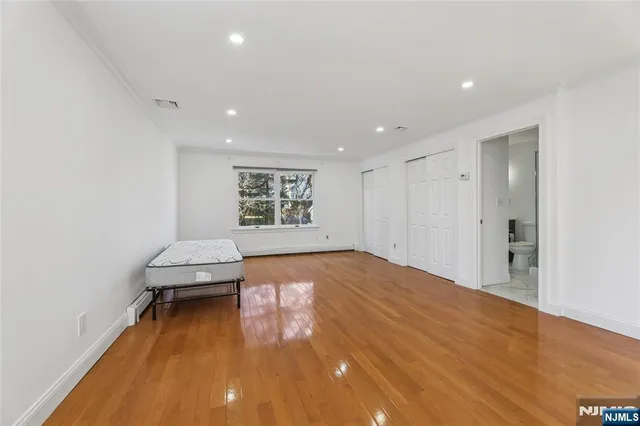 a view of empty room with a window and wooden floor