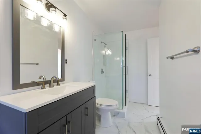 a bathroom with a sink toilet double vanity and shower