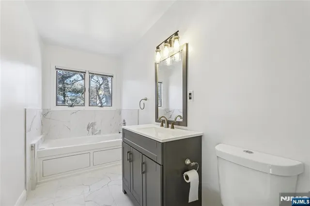 a bathroom with a sink a toilet and a mirror