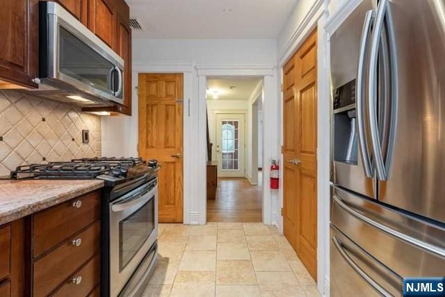 135 7th Street Cresskill, NJ 07626 - Photo 3 of 17 a kitchen with stainless steel appliances granite countertop a refrigerator and a stove