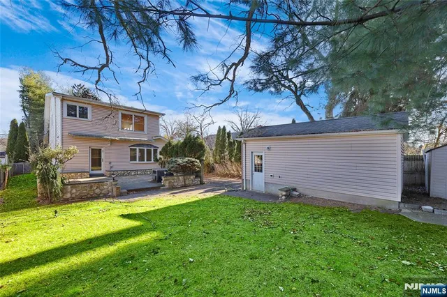 a view of a backyard with table and chairs and a barbeque