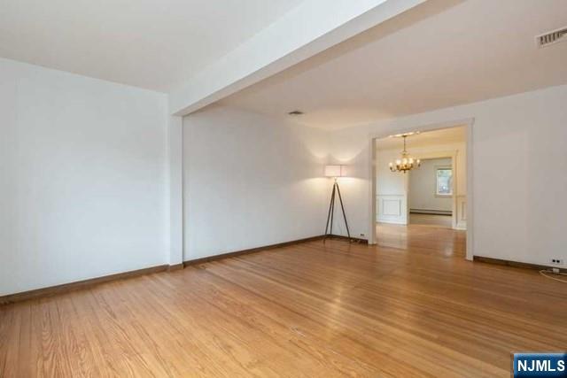 135 7th Street Cresskill, NJ 07626 - Photo 7 of 17 a view of an empty room with wooden floor and a window