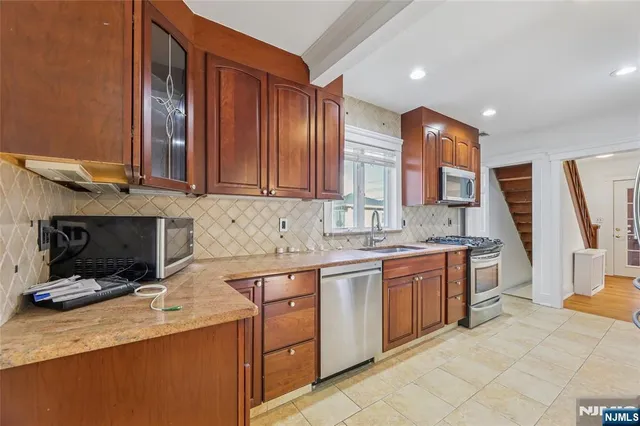 a kitchen with stainless steel appliances granite countertop a stove sink and cabinets