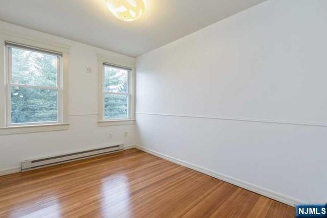 135 7th Street Cresskill, NJ 07626 - Photo 9 of 17 an empty room with wooden floor and windows