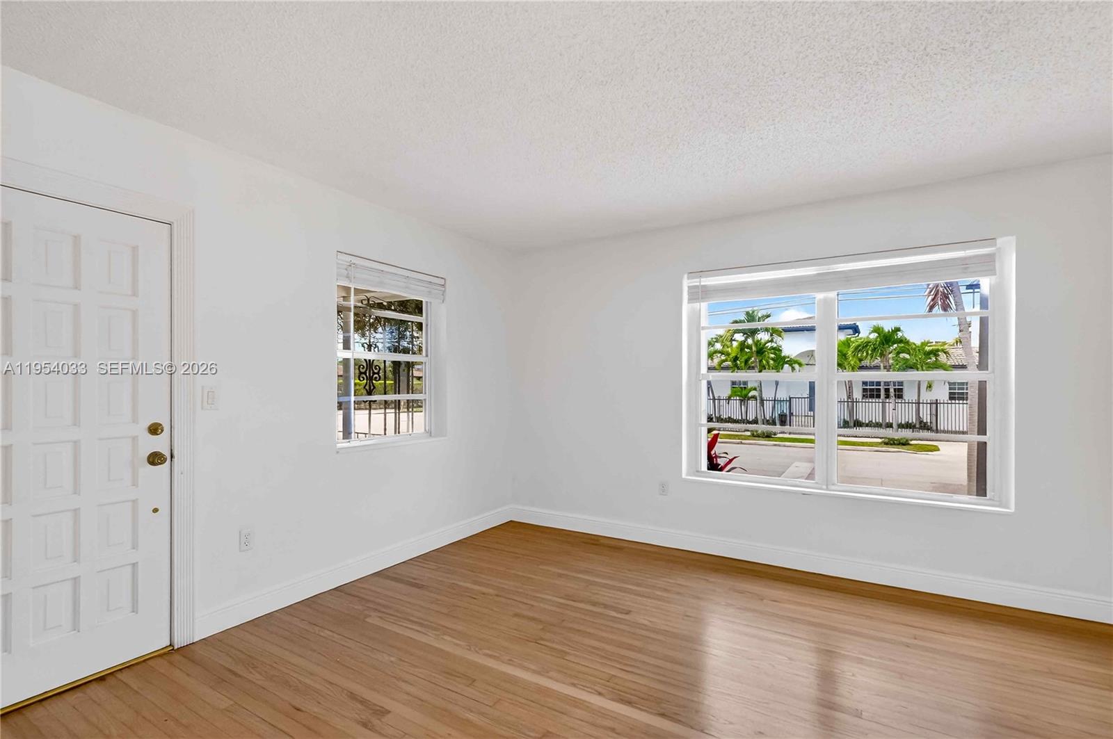 2399 Southwest 26th Lane Miami, FL 33133 - Photo 27 of 39 a view of an empty room with wooden floor and a window