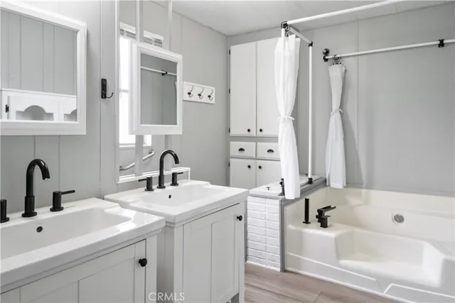 a bathroom with a tub sink and mirror