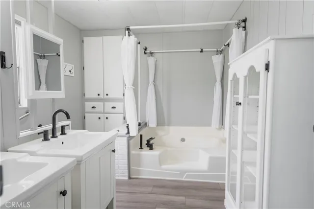 a bathroom with a tub sink and mirror