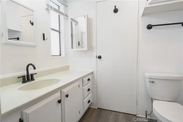 a bathroom with double vanity sink a toilet and a mirror