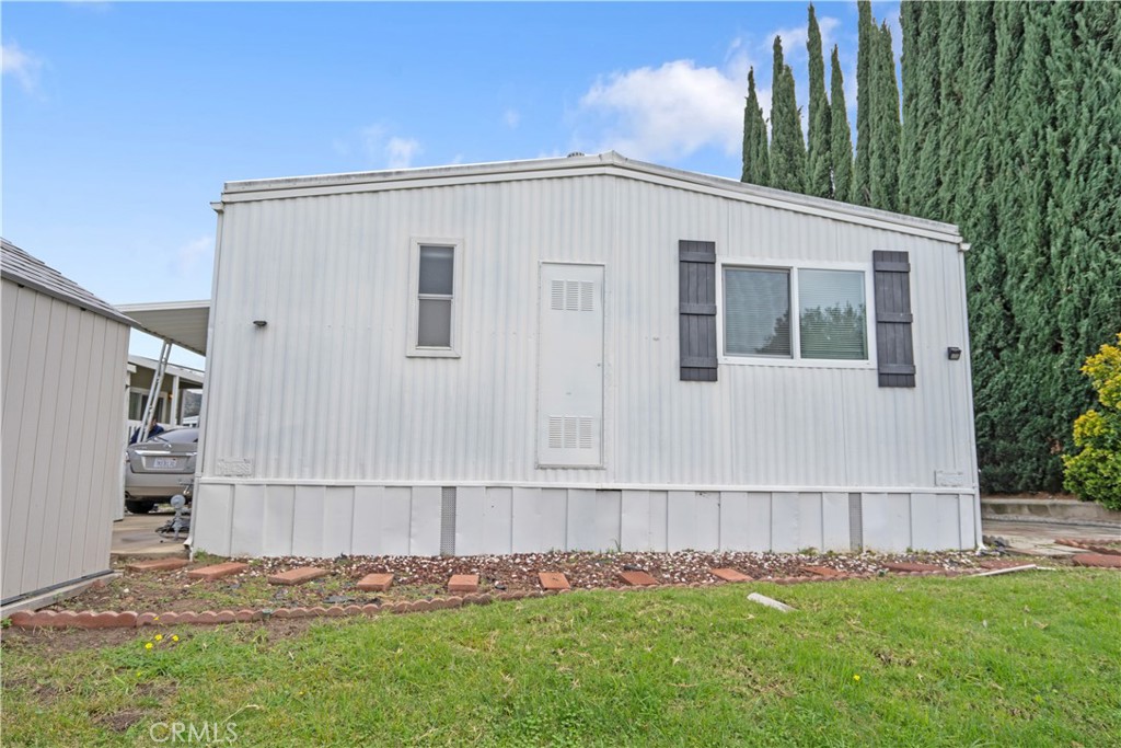 6480 Katherine, Unit 62 Simi Valley, CA 93063 - Photo 22 of 22 a white house with a big yard and plants