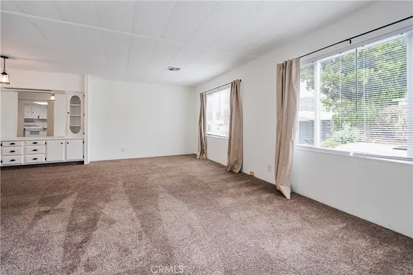 an empty room with windows and view of bathroom
