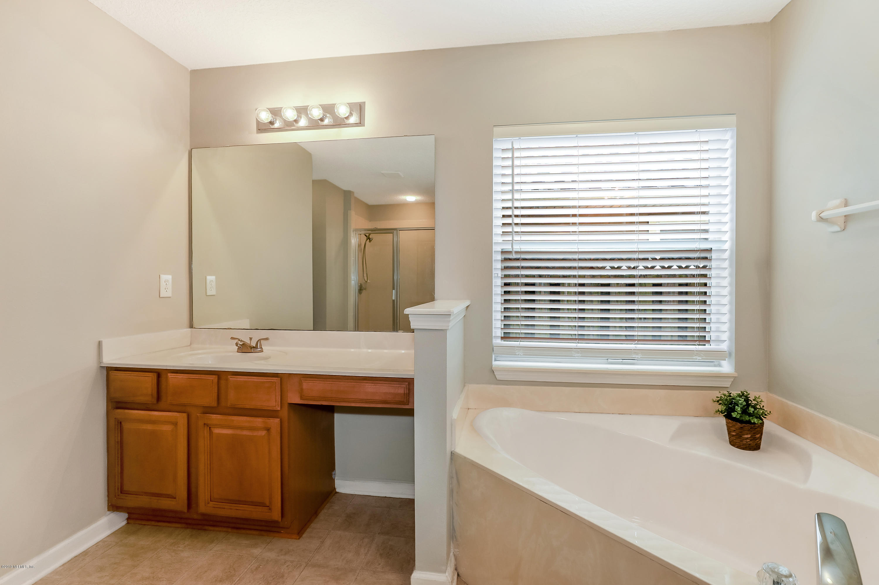 919 Silver Spring Court St. Augustine, FL 32092 - Photo 15 of 34 a bathroom with a tub a sink and a mirror