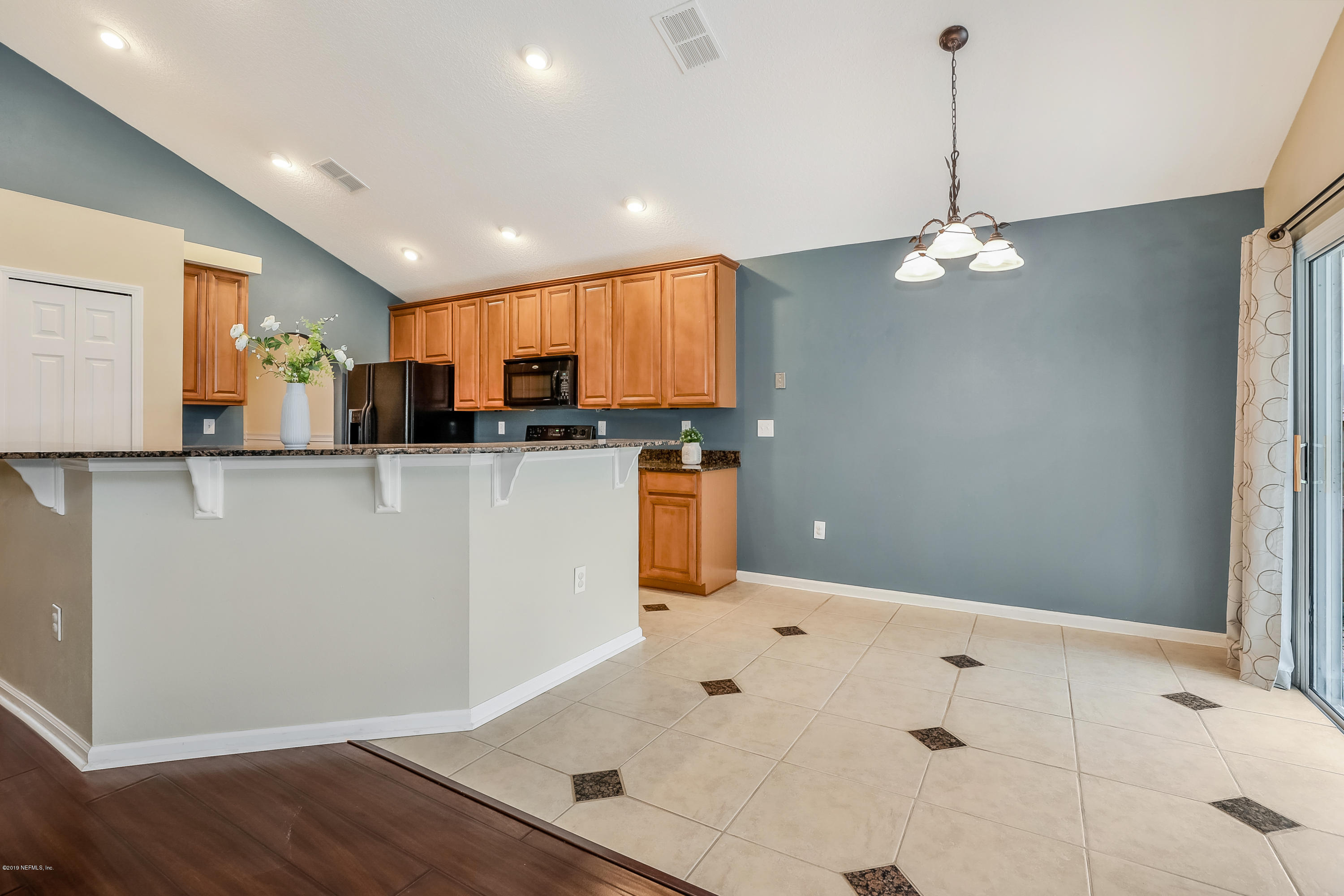 919 Silver Spring Court St. Augustine, FL 32092 - Photo 5 of 34 a kitchen with stainless steel appliances granite countertop a refrigerator a sink dishwasher a stove and white cabinets with wooden floor