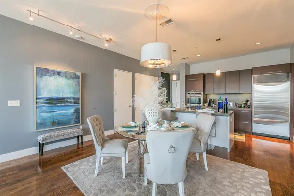a dining room with stainless steel appliances kitchen island granite countertop furniture and wooden floor