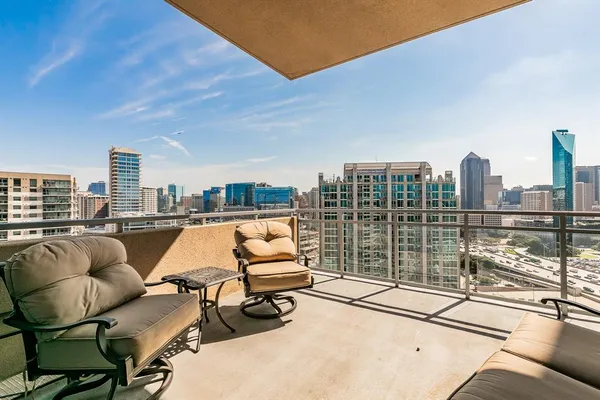 a balcony with furniture and view of city