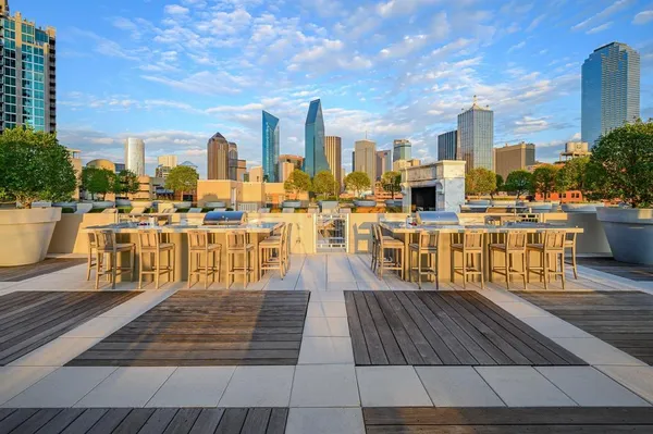 a view of a rooftop deck with chairs and wooden floor