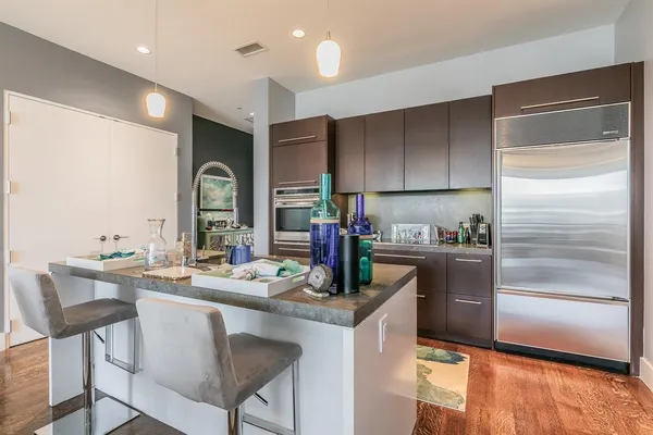 a kitchen with granite countertop a sink and a refrigerator