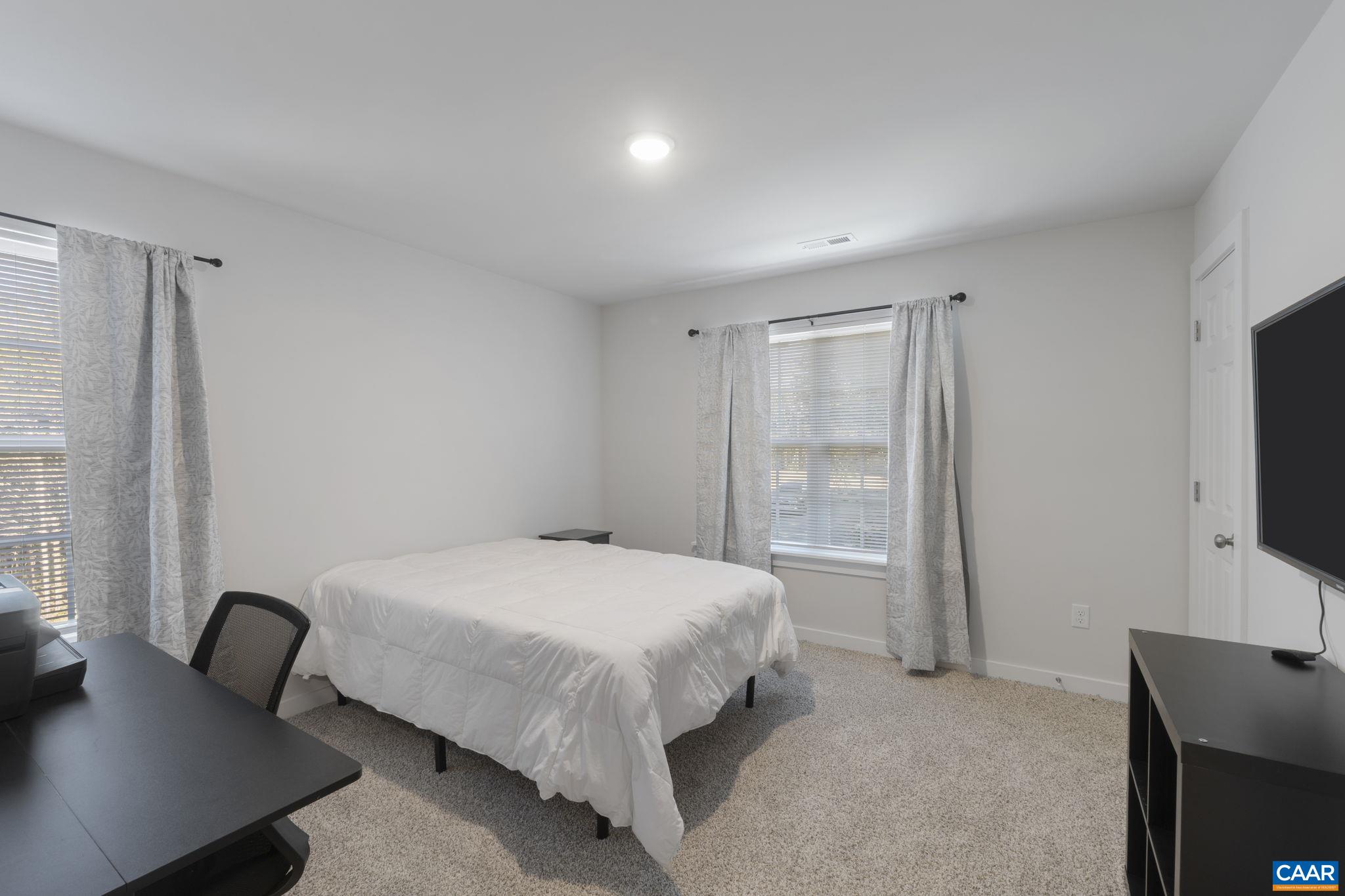 7440 Louisa Road Gordonsville, VA 22942 - Photo 25 of 40 a bedroom with a bed and a flat screen tv