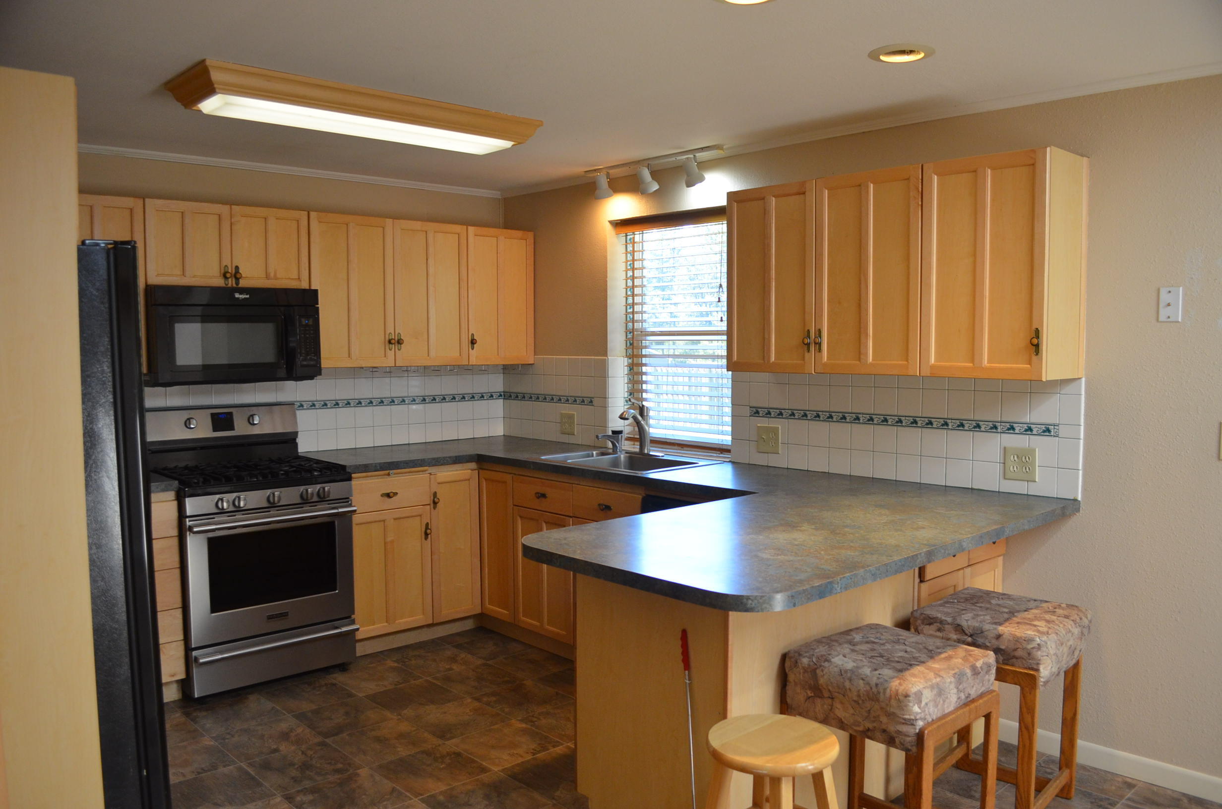 137008 Main Street Crescent, OR 97733 - Photo 7 of 50 a kitchen with stainless steel appliances granite countertop a stove a sink and a microwave
