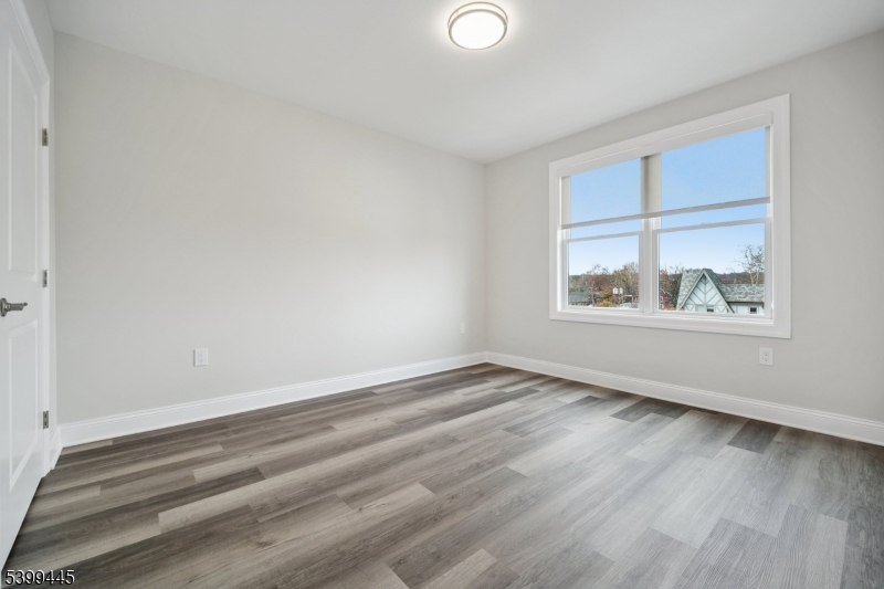 246 Main Street, Unit 304 Chatham, NJ 07928 - Photo 14 of 31 wooden floor in an empty room with a window