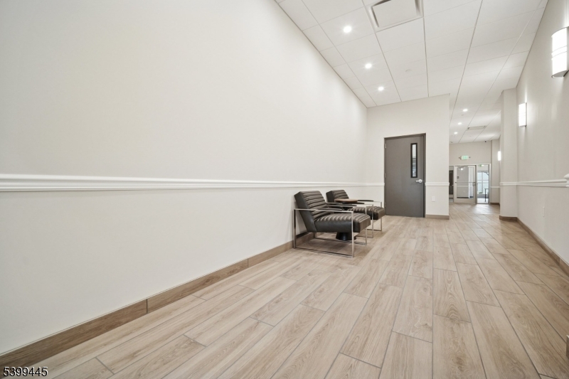 246 Main Street, Unit 304 Chatham, NJ 07928 - Photo 3 of 31 a living room with furniture and a wooden floor