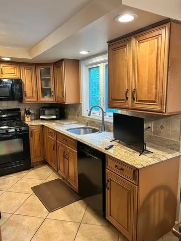 a kitchen with stainless steel appliances granite countertop a stove sink and cabinets