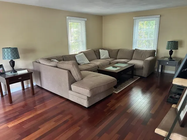 a living room with furniture a wooden floor and a window