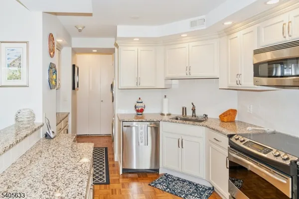 a kitchen with stainless steel appliances granite countertop a stove a sink and a refrigerator