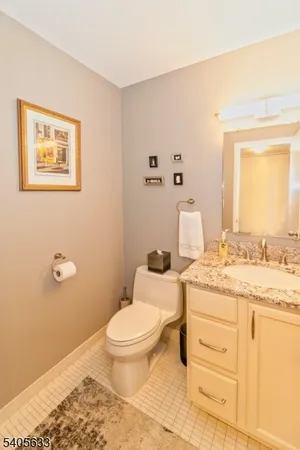 a bathroom with a granite countertop toilet sink and a mirror