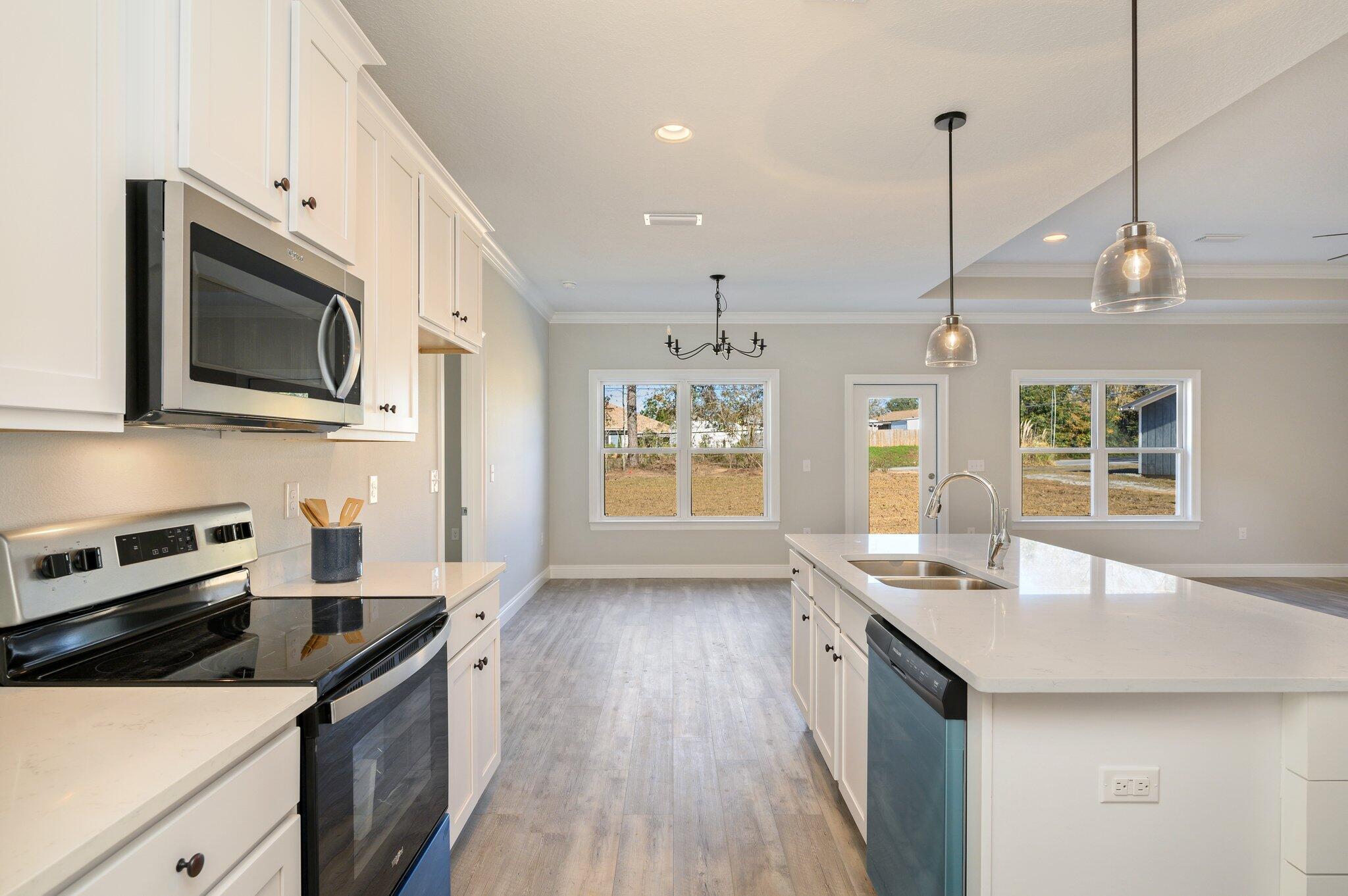 107 Winchester Way Crestview, FL 32539 - Photo 12 of 46 a kitchen with stainless steel appliances granite countertop a sink a stove and a wooden floors
