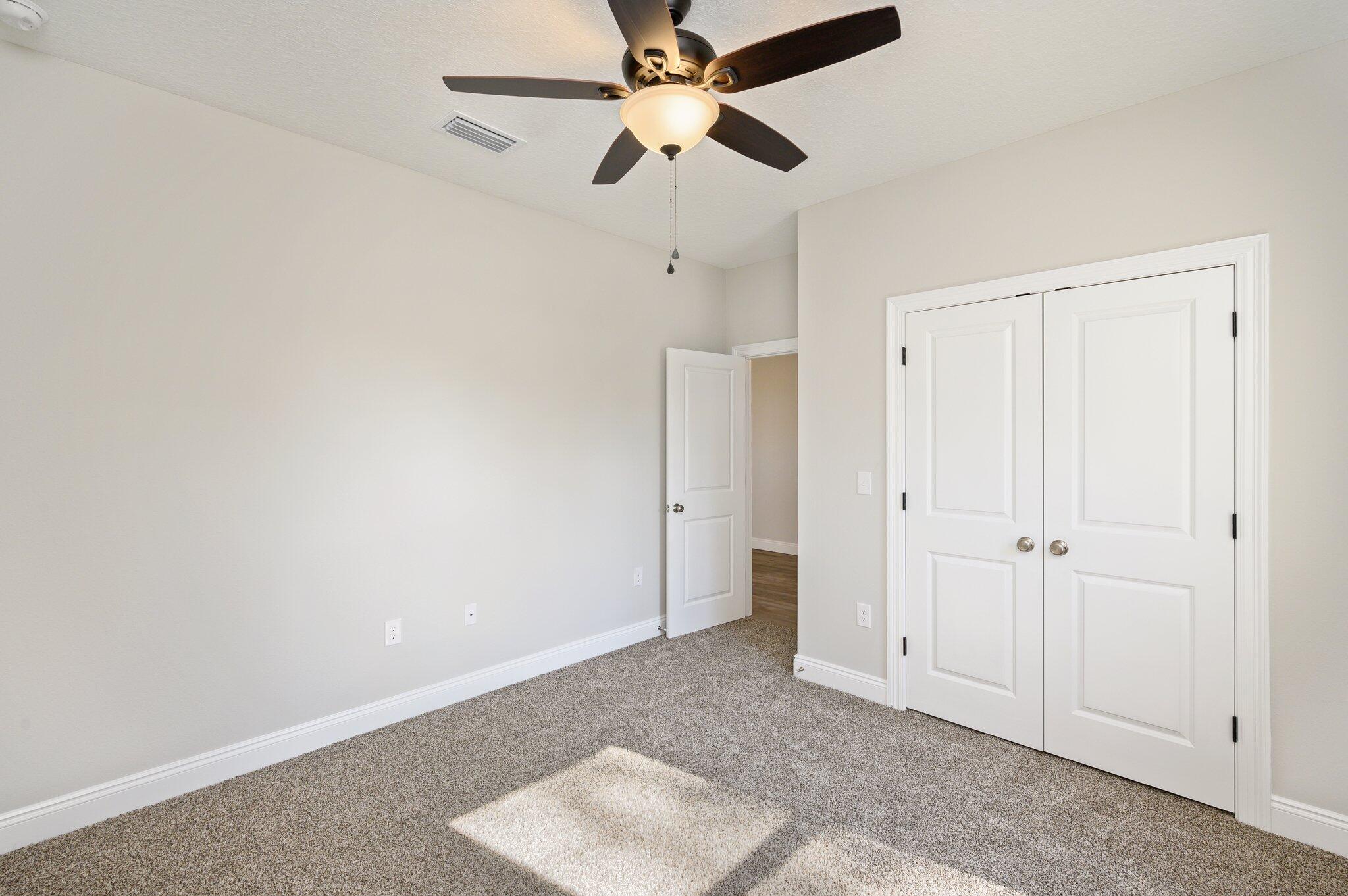107 Winchester Way Crestview, FL 32539 - Photo 22 of 46 an empty room with closet and a chandelier fan