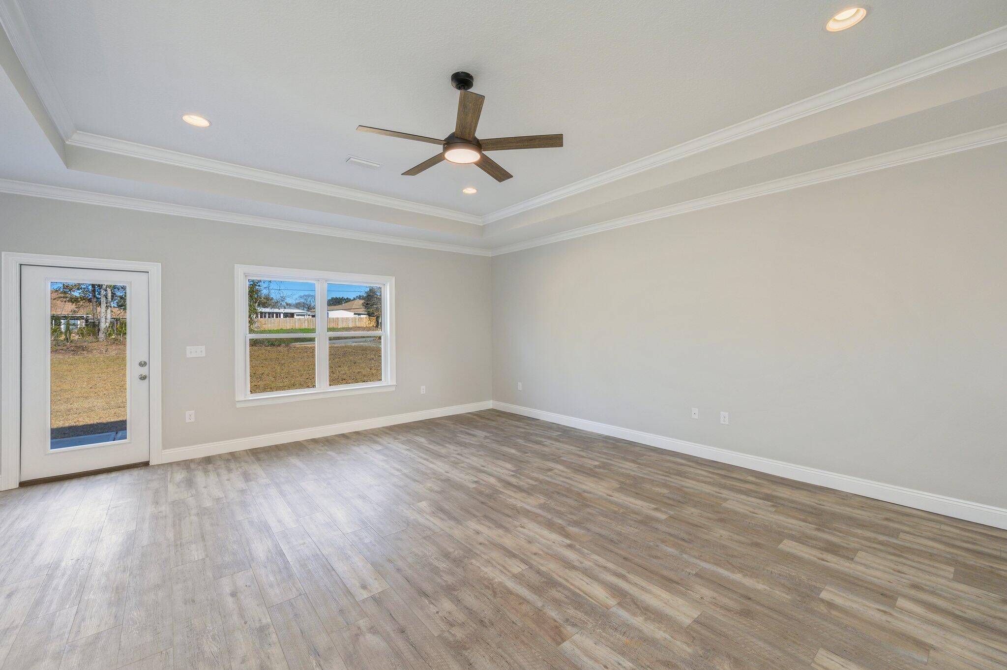 107 Winchester Way Crestview, FL 32539 - Photo 7 of 46 wooden floor in an empty room with a window