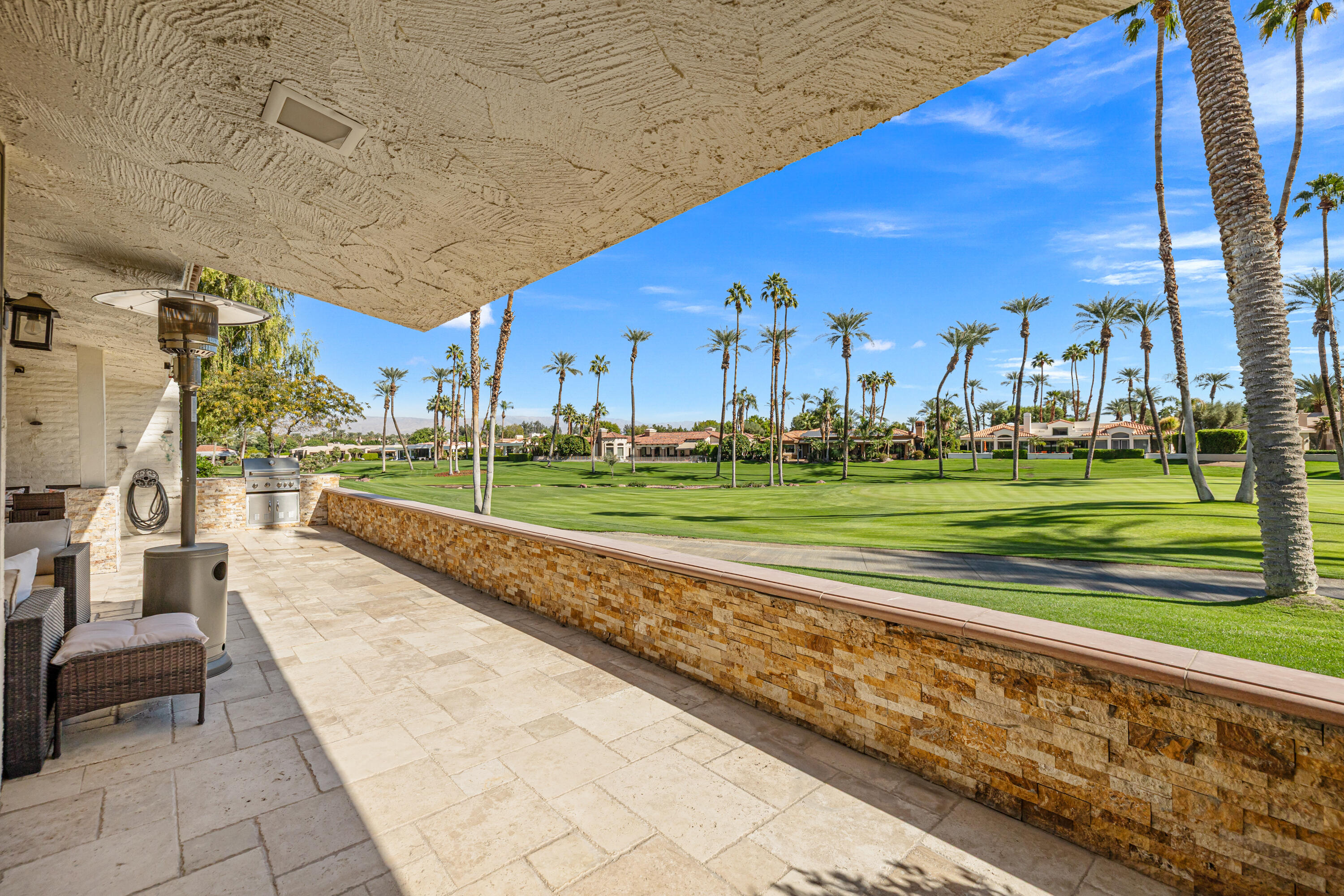 44828 Oro Grande Circle Indian Wells, CA 92210 - Photo 17 of 59 a view of a swimming pool with a lawn chairs and a big yard