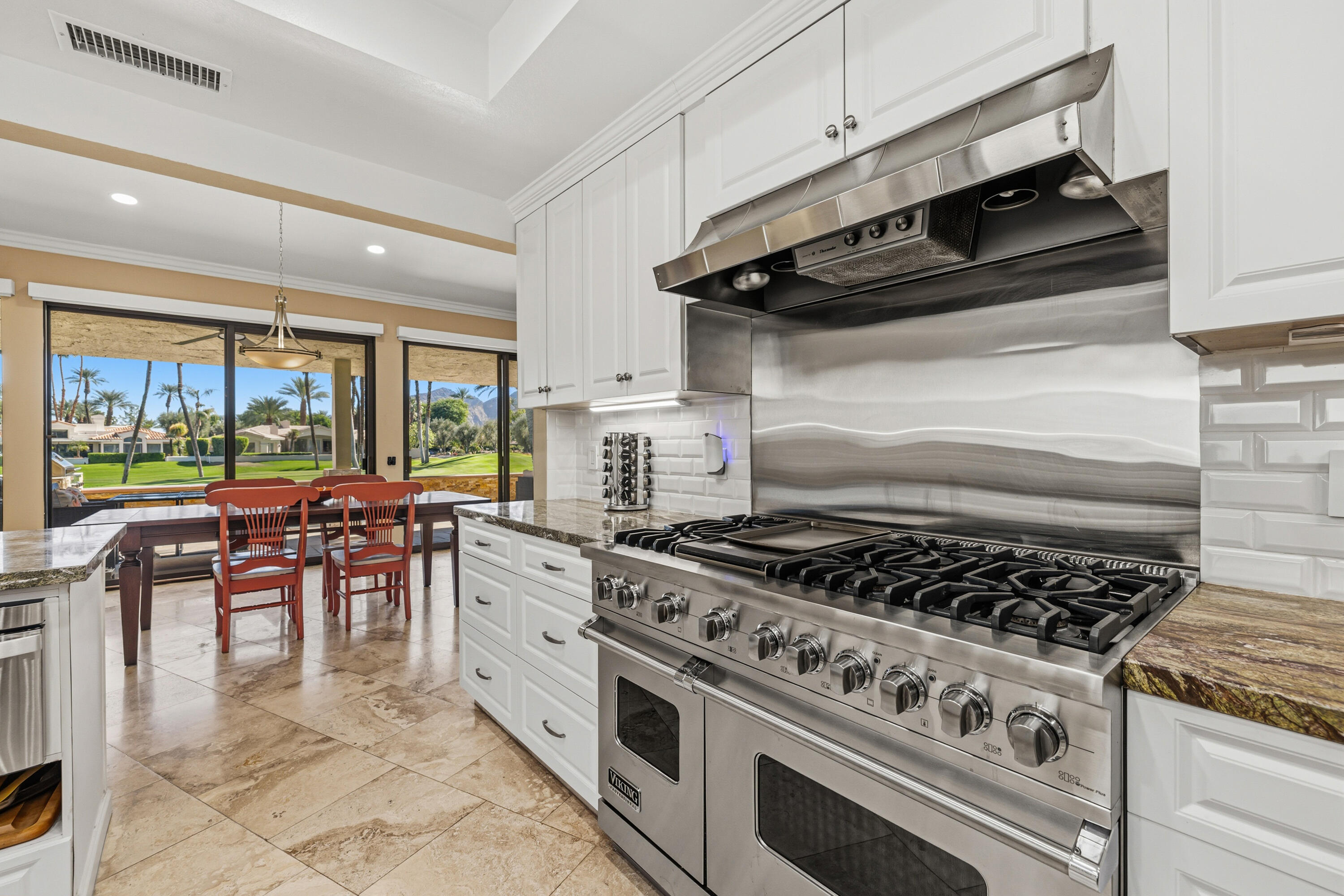 44828 Oro Grande Circle Indian Wells, CA 92210 - Photo 37 of 59 a kitchen with a stove a sink and chairs