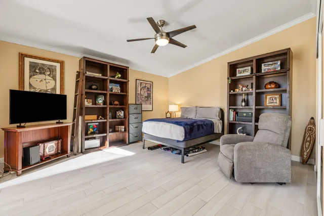 a bedroom with a bed a computer on desk and a chair