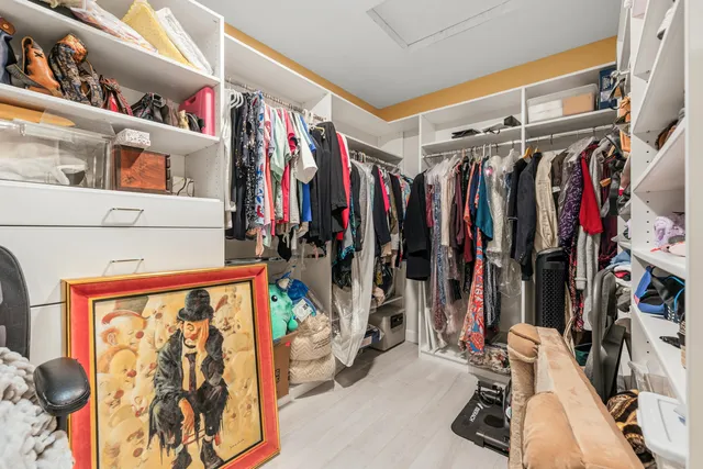 a bedroom with a bed a computer on a desk and chair