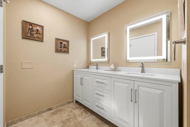 a spacious bedroom with a bed a table and painting on the wall