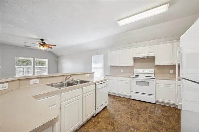 a kitchen that has a sink cabinets counter space and appliances