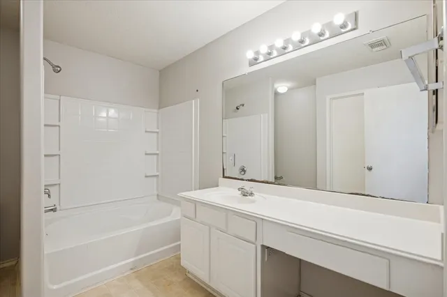 a bathroom with a tub a sink and a mirror