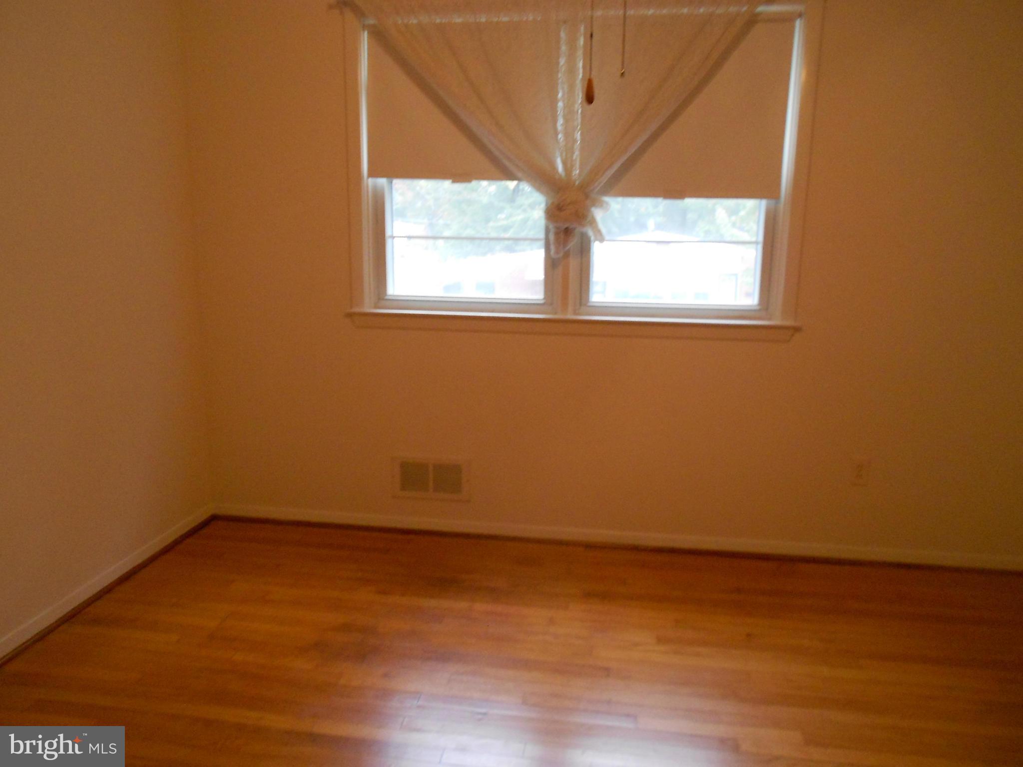 6235 Robin Hill Road Baltimore, MD 21207 - Photo 24 of 30 an empty room with wooden floor and windows