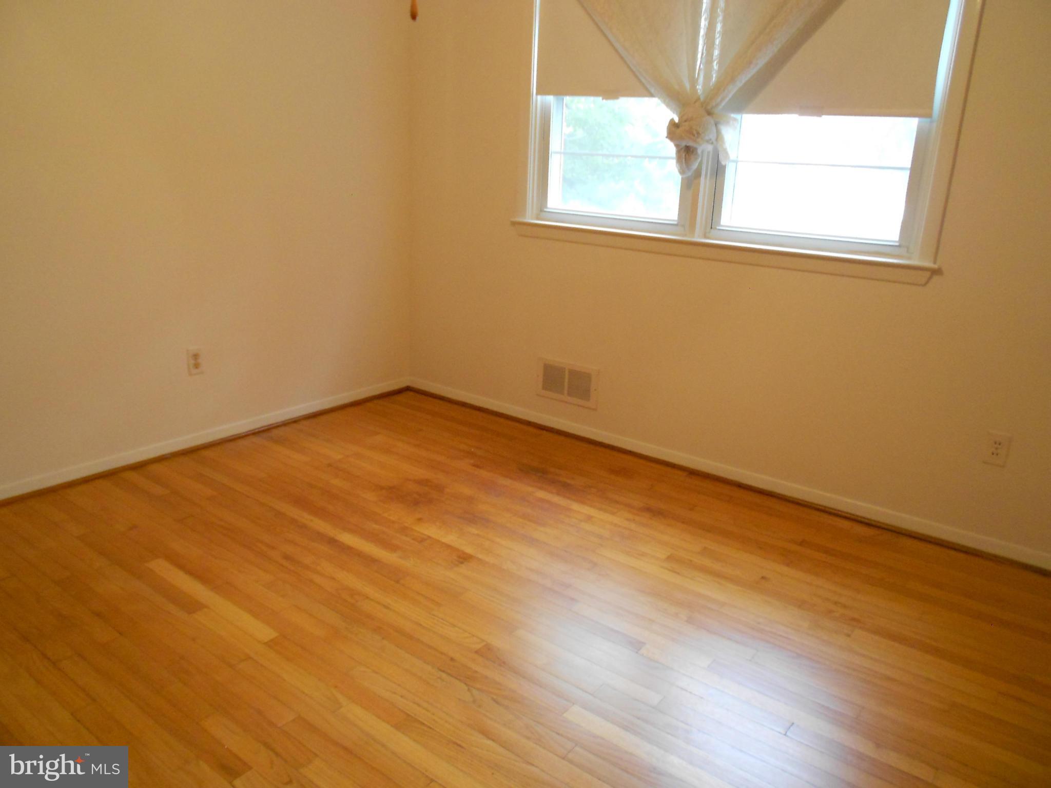 6235 Robin Hill Road Baltimore, MD 21207 - Photo 25 of 30 an empty room with wooden floor and windows