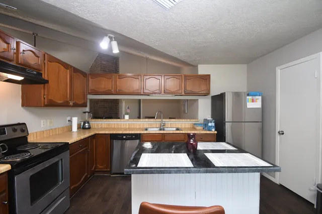 a view of a house with a yard and potted plants