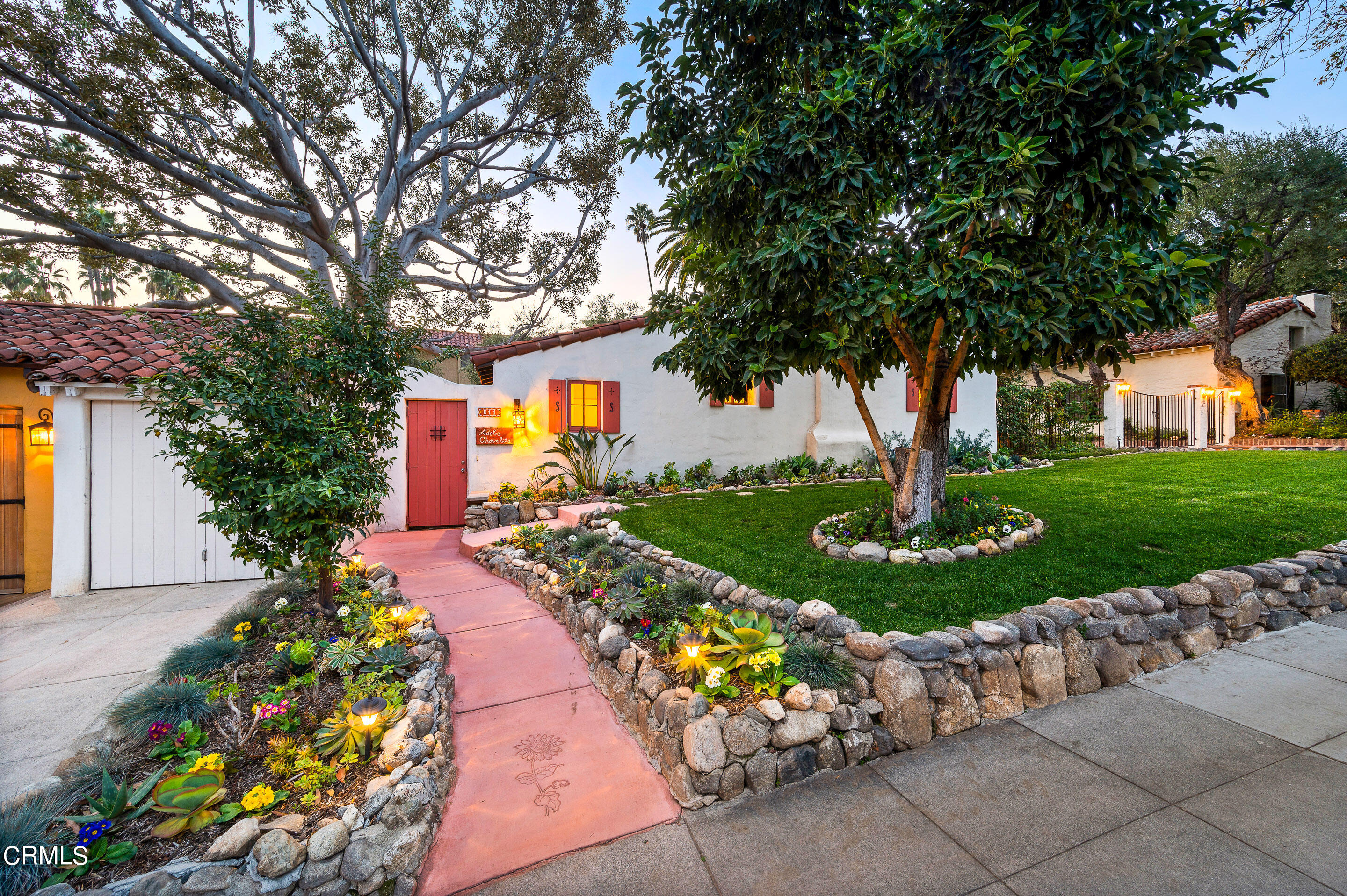 a front view of a house with a yard and a garden