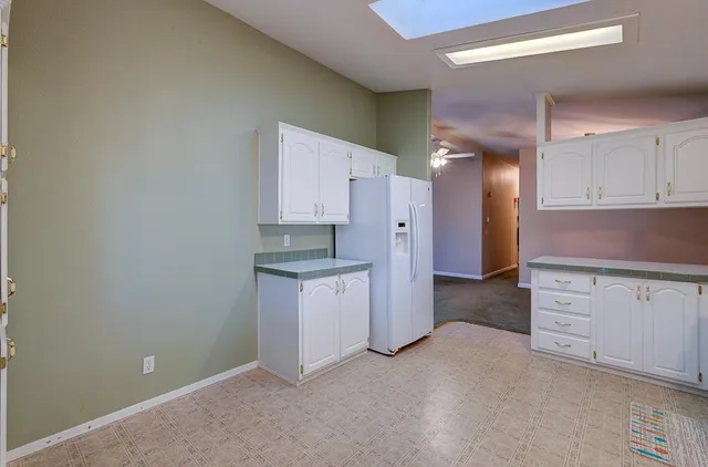 a kitchen with white cabinets and black appliances