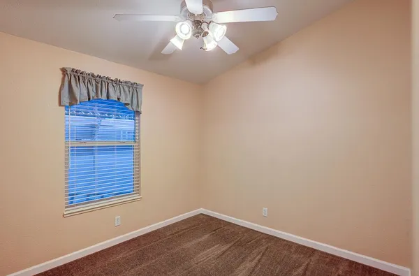 an empty room with chandelier fan