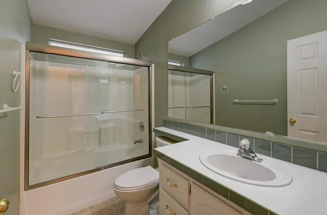 an empty room with a chandelier fan and windows